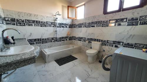 Un baño con bañera, inodoro y lavabo. en Gîte Hôtel Ramla Louxor 2, en Luxor