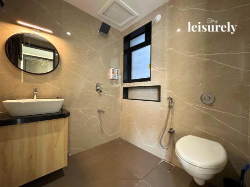 Stay Leisurely Casa Astre 3BHK, Karjat في كارجات: حمام مزود بمرحاض ومغسلة ومرآة