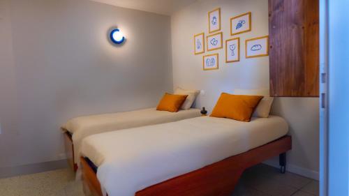 卢尔德Proche Sanctuaires - Confort Premium - Parking facile的配有白色和橙色枕头的客房内的两张床
