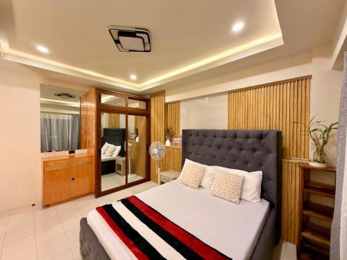 a bedroom with a large bed and a bathroom at Baguio Transient Across Burnham Park 2 - 2BR Condo in Baguio
