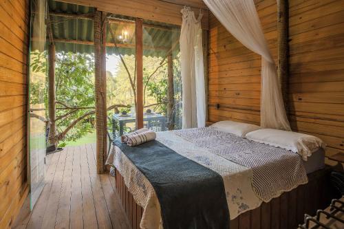 Una cama o camas en una habitación de Quinta do Vale: Casa da Árvore - em meio à mata, cascata, lago, piscina, caiaque