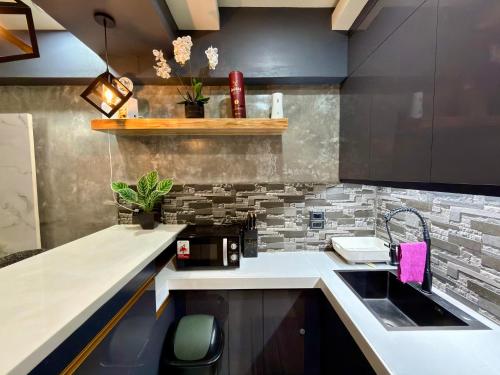 a kitchen with a sink and a counter at Baguio Transient Across Burnham Park 2 - 2BR Condo in Baguio