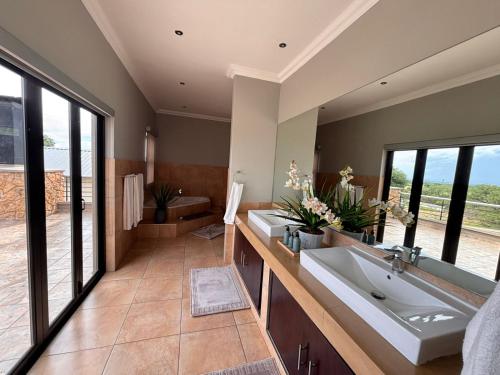 une salle de bain avec deux lavabos et un grand miroir dans l'établissement Euphoria Self Catering Home, à Naboomspruit