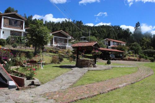 una casa y un jardín con un camino de piedra en Villa Patty, en Tibasosa