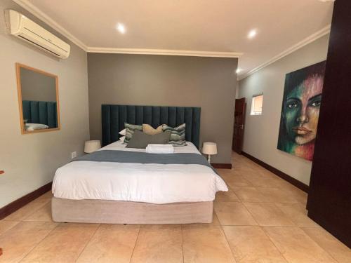 une chambre avec un grand lit et un tableau au mur dans l'établissement Euphoria Self Catering Home, à Naboomspruit