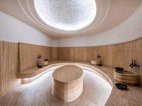 a room with a round table and two sinks at Swissôtel Tbilisi in Tbilisi City