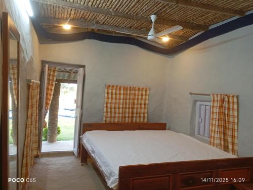 a bedroom with a bed and an open door at Nili Farm House in Shānti Niketan