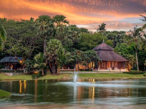 un étang en face d'un bâtiment avec une fontaine dans l'établissement Pullman Phuket Karon Beach Resort, à Karon Beach
