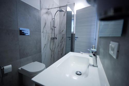 a bathroom with a toilet and a sink and a shower at Max in Condofuri