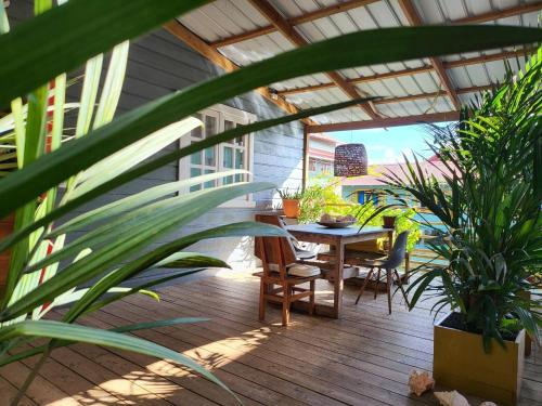 Un patio con mesa y sillas y plantas. en Chalet over the Caribbean sea, en Istmito
