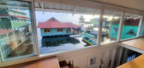 una ventana con vistas a un puerto deportivo con una casa en Chalet over the Caribbean sea, en Istmito
