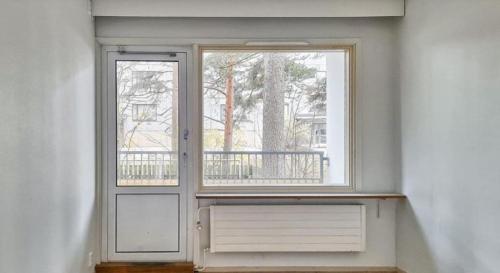 an empty room with a window and a radiator at Kotimaailma - kolmio Kotkan kupeessa in Kotka