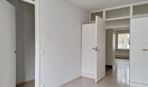 an empty room with white walls and doors at Kotimaailma - kolmio Kotkan kupeessa in Kotka