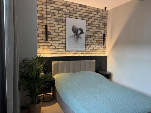 a bedroom with a bed and a brick wall at Apartament Wileńska 2 in Słupsk