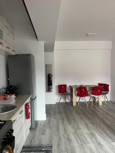a kitchen with red chairs and a table at AN Studio in Craiova