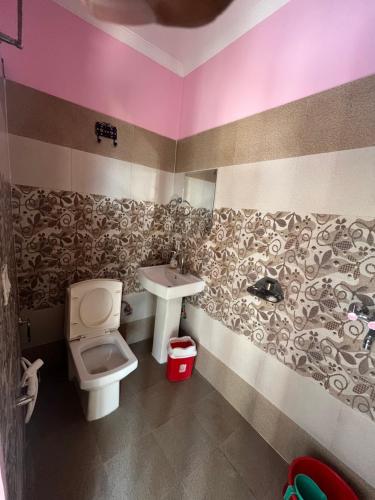 un baño con inodoro y lavabo en Hostel Cozy Bedz, en Rishīkesh