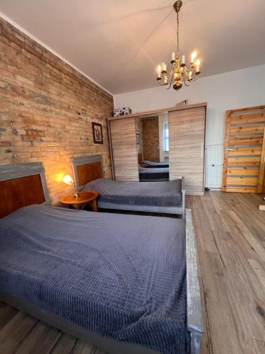 a bedroom with two beds and a brick wall at Louis Apartaments in Skorka