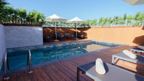 une piscine avec tables et chaises sur une terrasse dans l'établissement Residence Eden Marrakech, à Marrakech