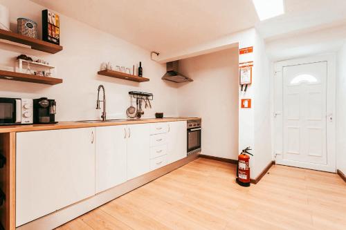 eine Küche mit weißen Schränken und einem Holzboden in der Unterkunft Alentejo Poolside By Gt House in São Domingos de Ana Loura