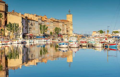 a group of boats docked in a harbor with buildings at Cocon jungle bohème 12 min de la mer in Martigues
