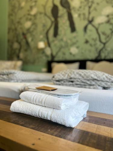 a pile of towels sitting on a table next to a bed at Victoria Apartment 1901-Apartament ultracentral Oradea ,lângă Piața Unirii in Oradea