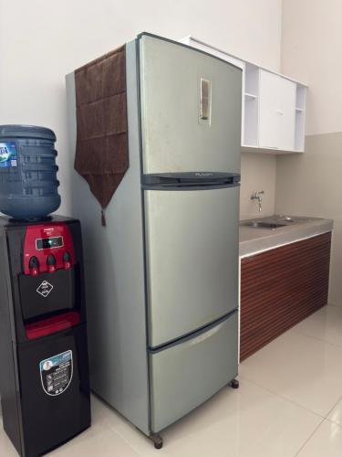 a refrigerator in a kitchen next to a sink at Kalakoala by Zzz in Malang