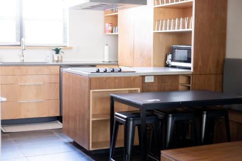 eine Küche mit Holzschränken und einem Tisch mit Stühlen in der Unterkunft Elegant 2BR Escape in Manhattan with WiFi & Parking in Manhattan