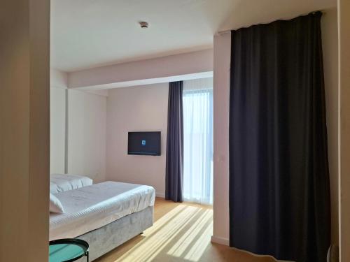 a hotel room with a bed and a window at Hotel Mooma in Skopje
