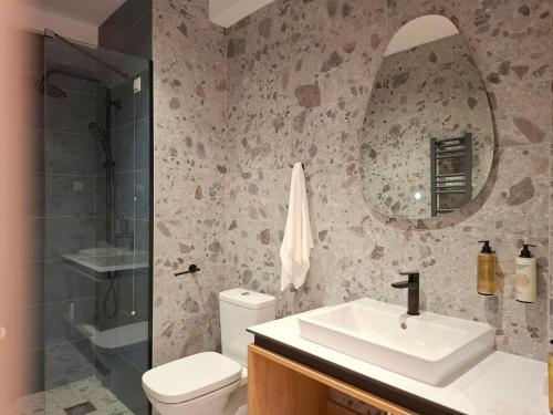 a bathroom with a sink and a toilet and a mirror at Hotel Mooma in Skopje