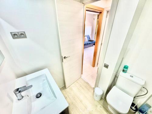 ein weißes Badezimmer mit Toilette und Waschbecken in der Unterkunft Apartsalou Zen in Salou