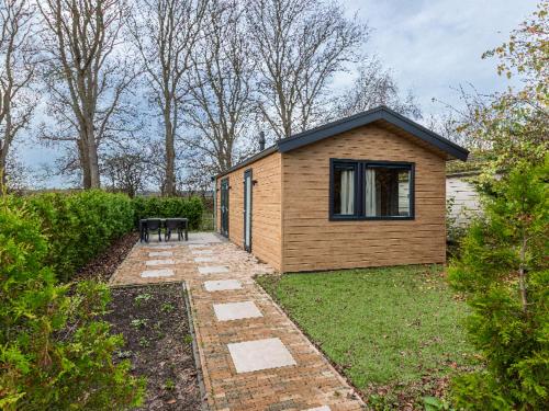 ein kleines Holzhaus mit einer Bank im Hof in der Unterkunft Rekerlanden 260 in Schoorldam