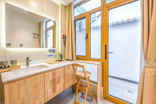 a bathroom with a sink and a chair next to a window at The Hutong Courtyard-Very close to Tiananmen Square,Forbidden City,Wangfujing Commercial Street,The hotel has a terrace,Free coffee,Free laundry,Near the subway st ation in Beijing