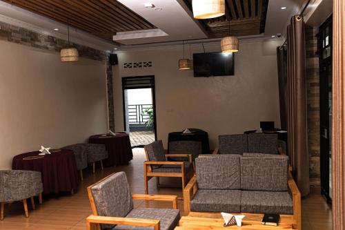 uma sala de espera com cadeiras e mesas e uma televisão em RP Gorilla Guest & Coffee em Taba