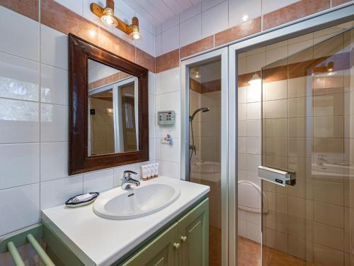 a bathroom with a sink and a mirror and a shower at Chalet calme avec terrasse, proche pistes, Méribel - FR-1-565-37 in Les Allues