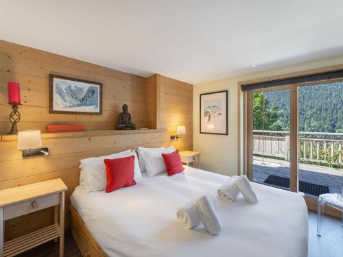 a bedroom with a large white bed and a window at Chalet calme avec terrasse, proche pistes, Méribel - FR-1-565-37 in Les Allues