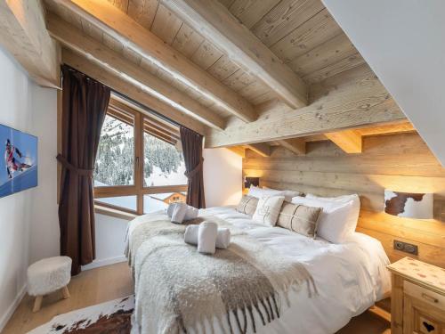 ein Schlafzimmer mit einem großen Bett und einer Holzdecke in der Unterkunft Chalet moderne 5 chambres à Méribel, proche pistes - FR-1-565-72 in Les Allues