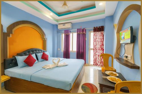 une chambre avec un lit dans une pièce aux murs bleus dans l'établissement Manisha Road Bhumishree Palace Resort - Free Wifi & Parking Facilities #Fully Air conditioned- Prime Location# Premium Hotel IN Puri, à Purî