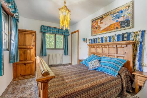 ein Schlafzimmer mit einem Holzbett mit blauen Kissen in der Unterkunft La Casita Del Valle in Villamena 