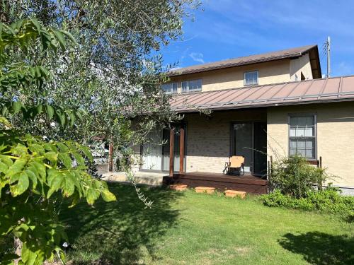 a house with a porch and a yard at House tomari木-山梨 in Yamanashi