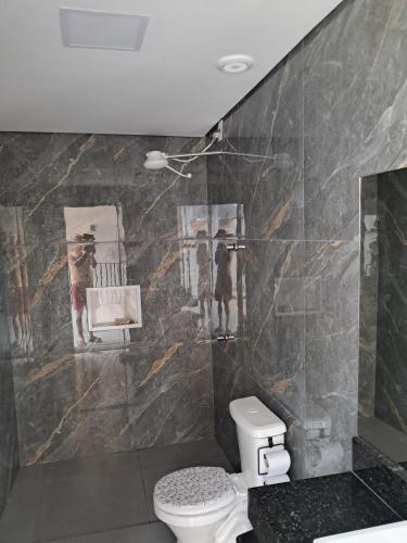 a bathroom with a toilet and paintings on the wall at Casa com piscina Espaço teddy cakes in Campinas