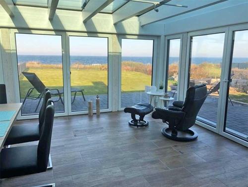 una stanza con sedie, un tavolo e finestre di Ferienbungalow Fehmarnblick a Presen