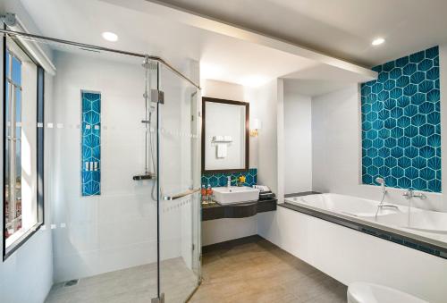 a bathroom with a shower and a tub and a sink at Amari Vang Vieng in Vang Vieng