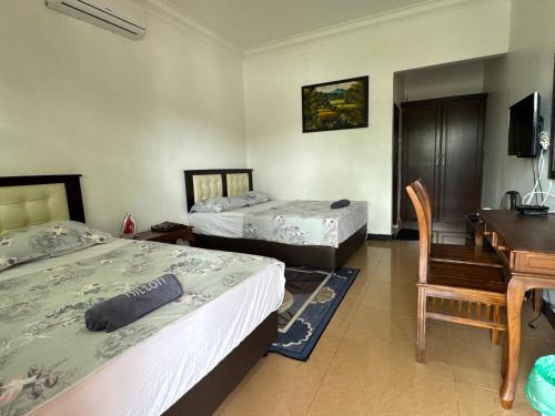 a bedroom with two beds and a desk and a desk at Villa Desa Permai in Sungai Besar