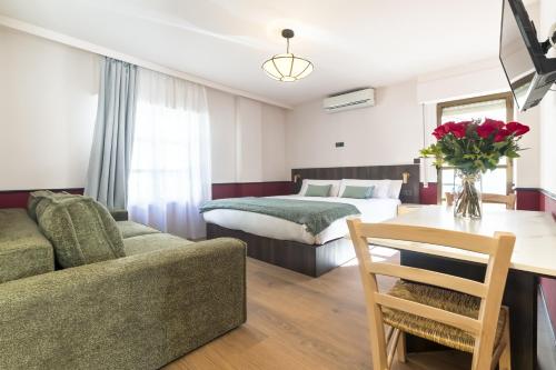 a bedroom with a bed and a couch and a table at Casa Lavanda in Granada
