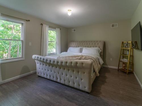 a bedroom with a large bed and two windows at 3BR Comfort Hub Newark 15 mins NYC in Jersey City