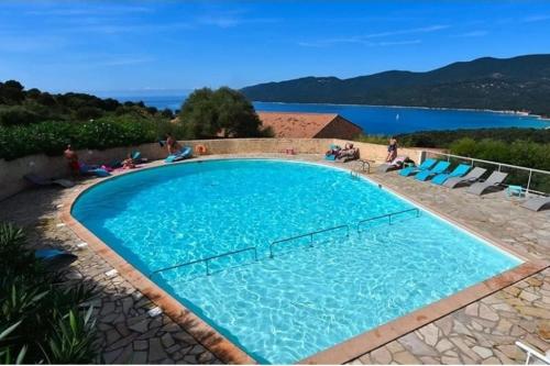 塞拉迪费罗Appartement climatisé dans une résidence avec piscine mer à pied的一个大型蓝色游泳池,周围的人坐在游泳池周围