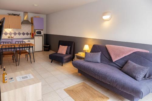 Appartement 225 في سيرا-دي-فيرو: غرفة معيشة بها أريكة أرجوانية ومطبخ