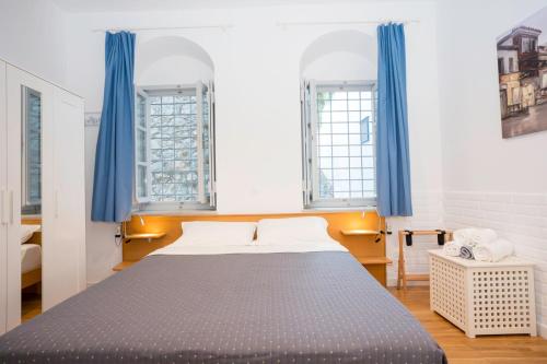 a bedroom with a large bed with blue curtains at Hydra's Ruby in Hydra