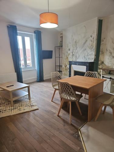 a living room with a table and chairs and a fireplace at Appartement coquet à la Machine in La Machine