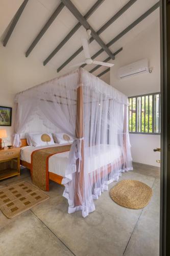 una camera da letto con due letti e una zanzariera di Old Chilli House a Unawatuna